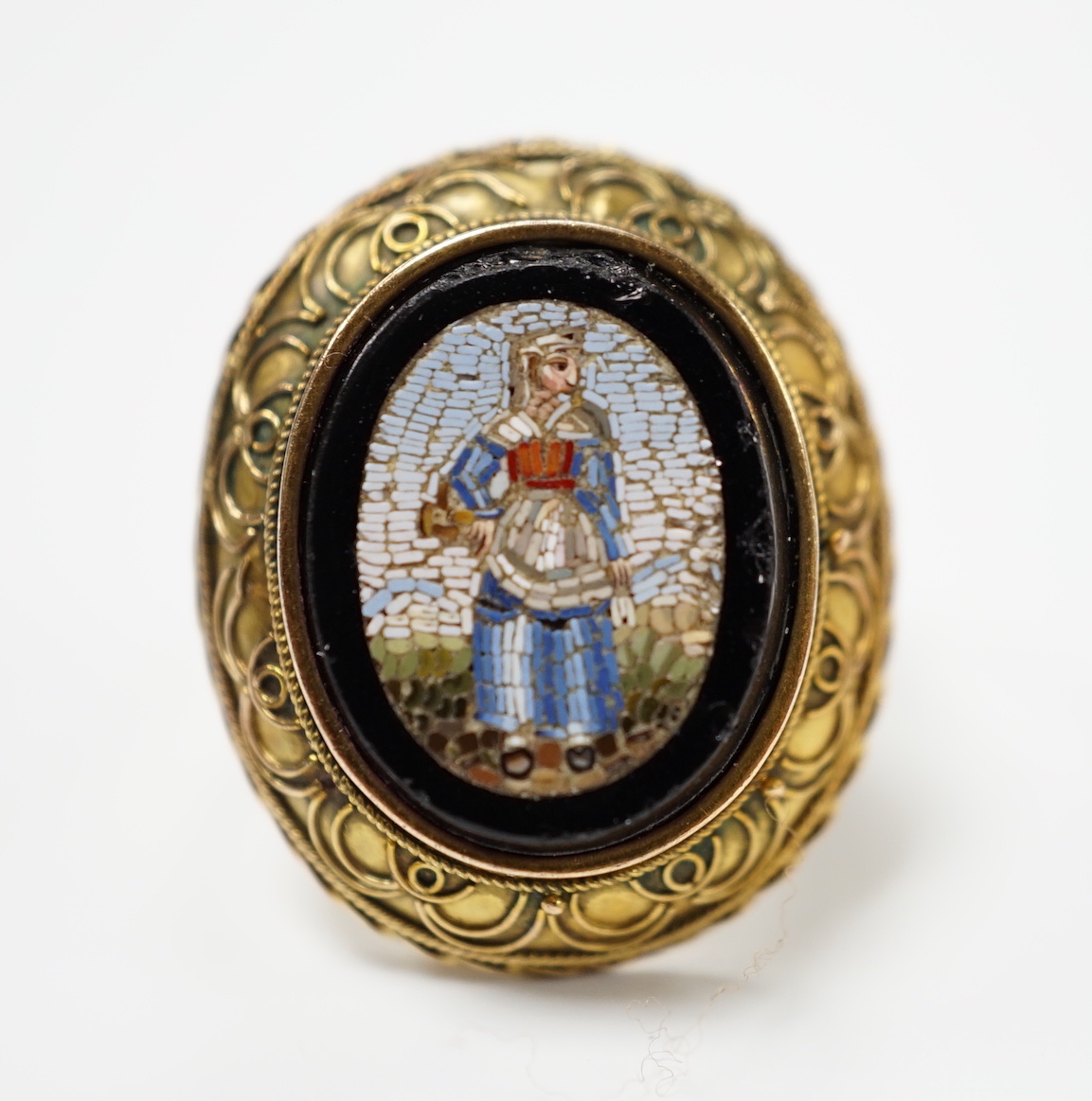 A 19th century yellow metal and oval micro mosaic set ring, depicting a warrior, size O.